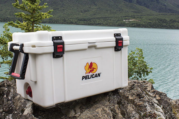 White Pelican cooler sitting on a rock in front of a lake 