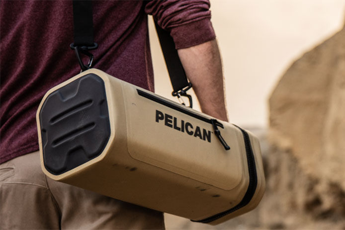 Pelican soft side cooler being carried on the shoulder on a man hiking