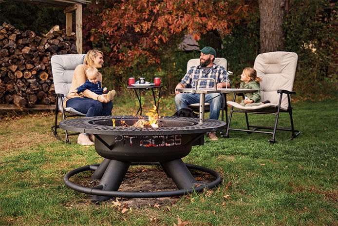 A family sitting around a Pitboss firepit enjoying the outdoors