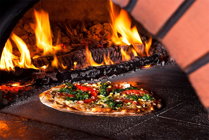 Pizza baking in a brick pizza oven.