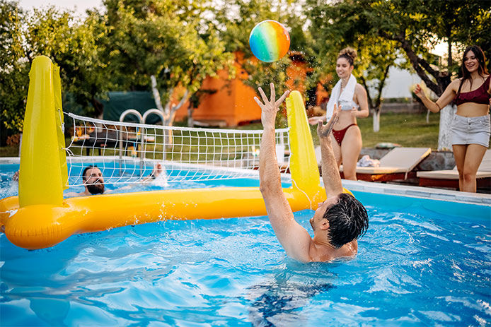 Friends playing volleyball in the swimming pool