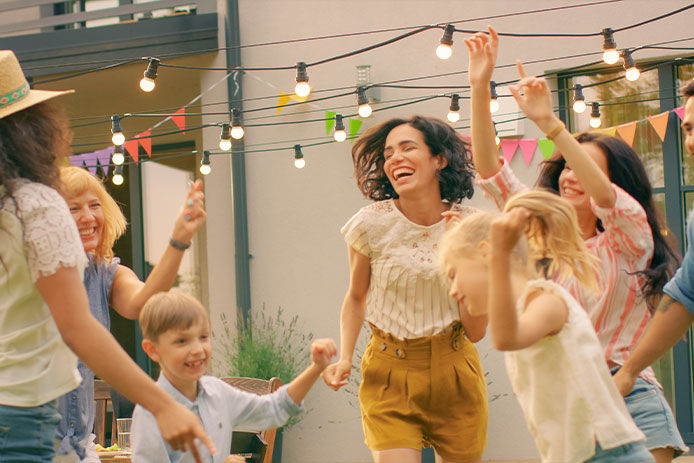 Guests dancing and having fun outside under patio lights