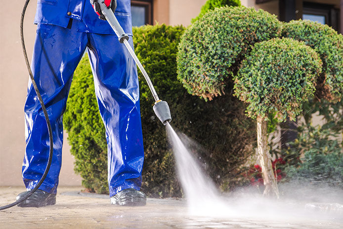 Man power washing driveway