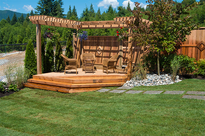 Newly Landscaped Outdoor Space with a wood deck and wicker patio furniture