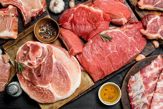 a top down veiw of a variety of cuts of meats surrounded by spieces and oils