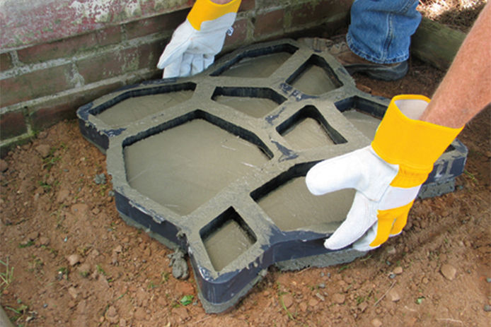 A person removing the Quikrete WalkMaker form after filling it with concrete