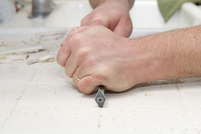 Removing old group from between tile with a removal tool