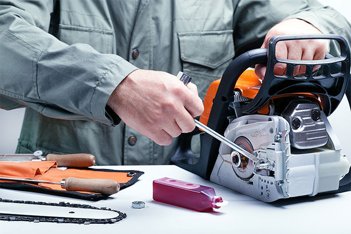 Man taking apart the chainsaw to replace the bar and chain