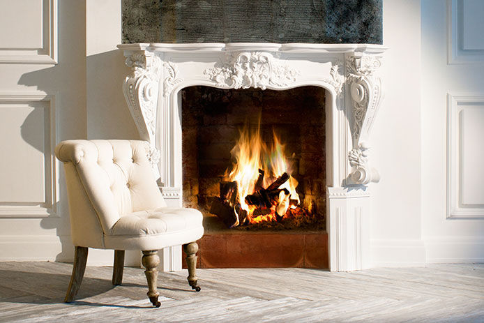 white crown moulding on fireplace surround with a fire going