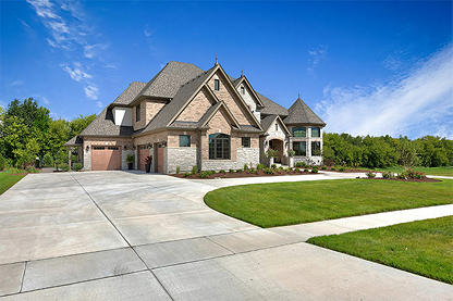 Large home with driveway leading to three car garage