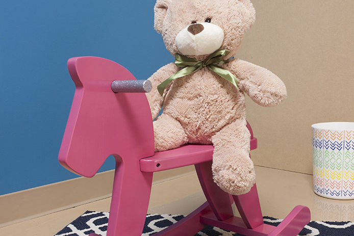 Pink rocking horse with a teddy bear