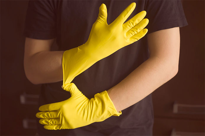 man wearing yellow rubber gloves ready to clean