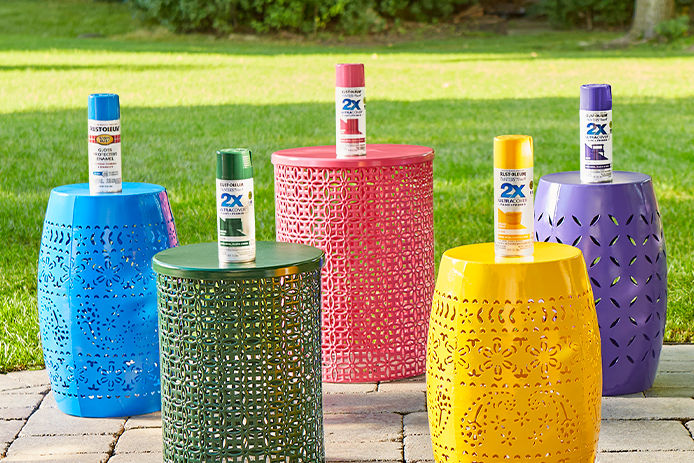 Rust-Oleum 2X Spray Paints sitting on top of painted metal barrels