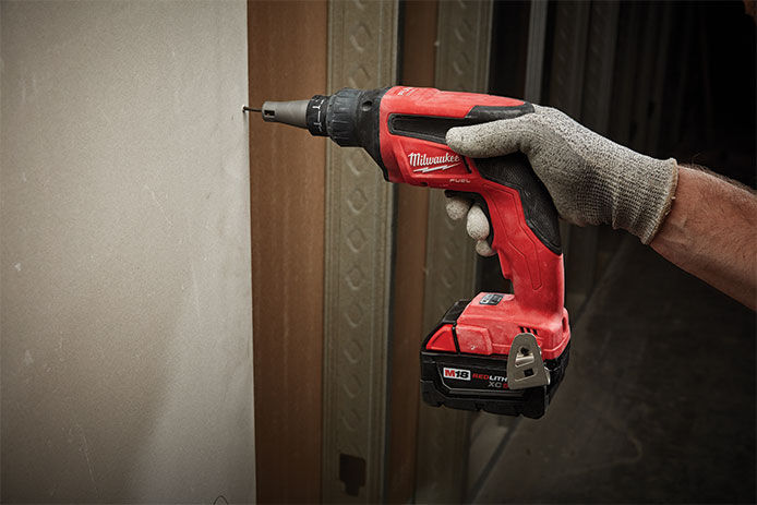A Milwaukee M18 cordless power screwgun being used to hang up drywall 