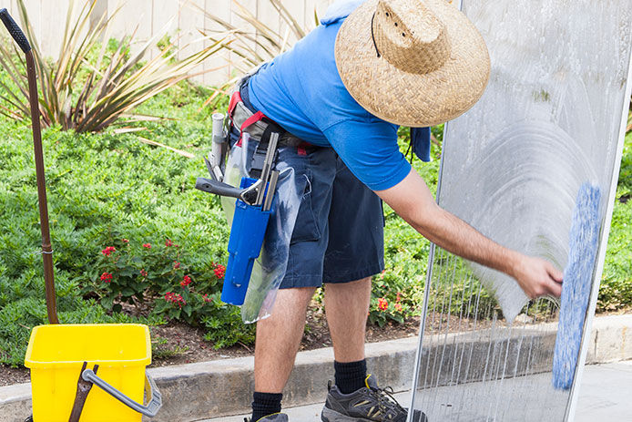 Man using a mircrofiber to wash window screen