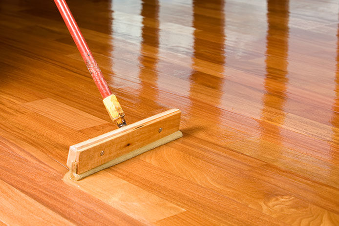 Applying the sealer to wood stained floor