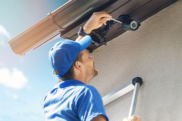 Man installing security cameras for a homeowner