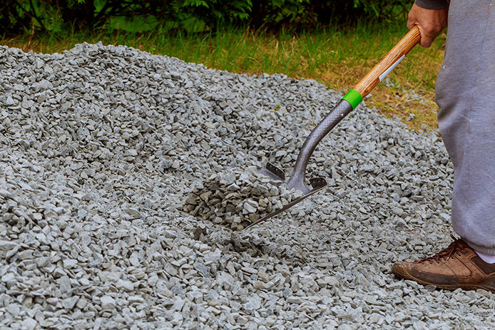 Spreading gravel manually with shovels dirty shovel working 