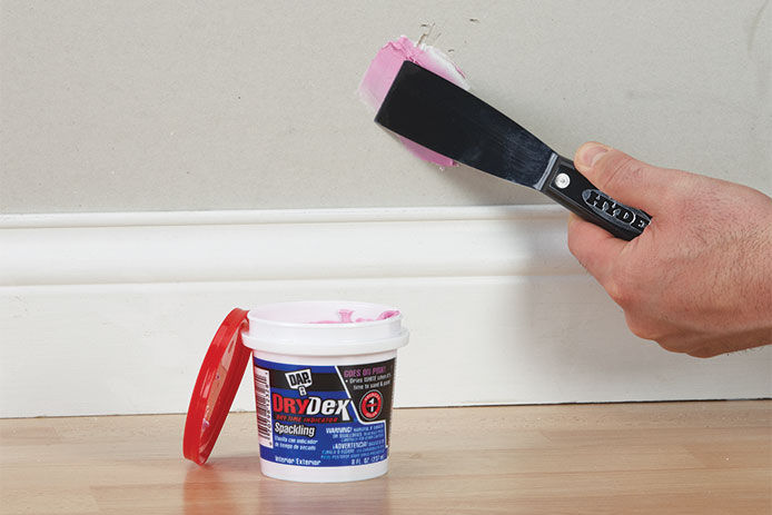 Spackling being applied to a wall to fill a small hole