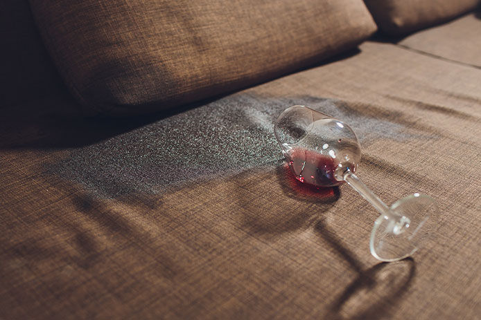 A spilled wine glass on a couch