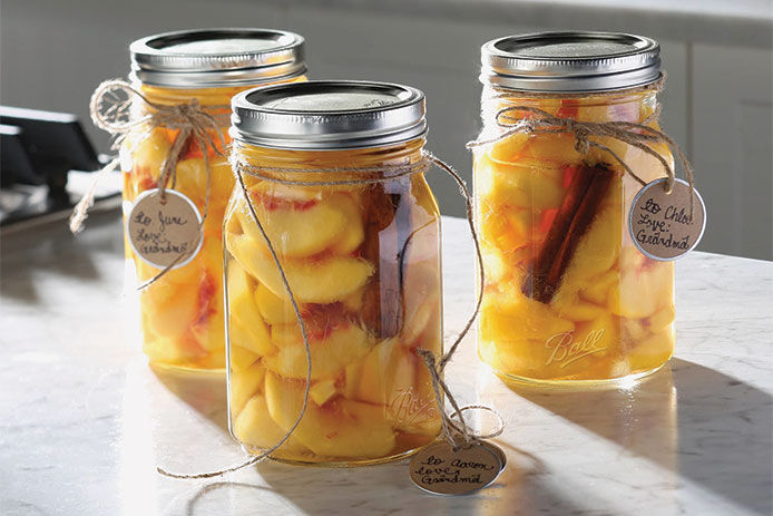 The final product, jars of canned fruit on kitchen countertop