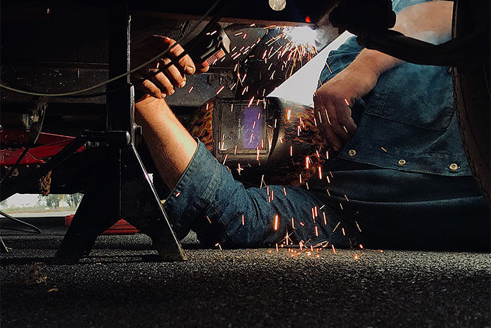 Man welding his trailer frame