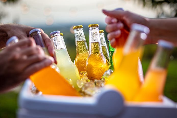 Grabbing ice cold beer bottles from a cooler