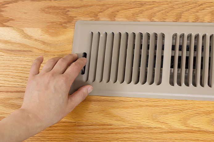 A person closing off an air vent