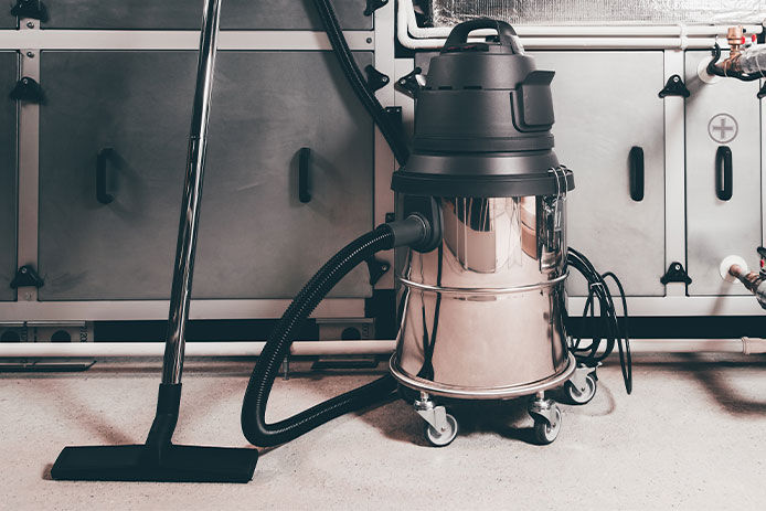 A wet/dry vacuum with cabinets behind it