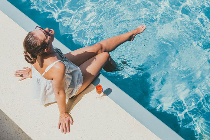 Woman sun bathing poolside