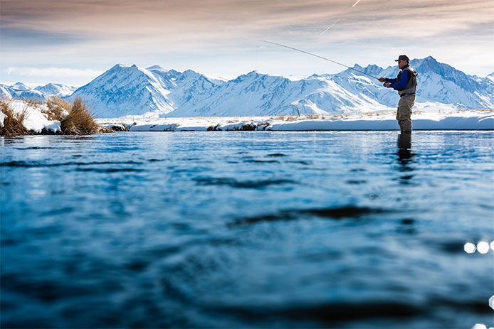 A man river fishing in the winter