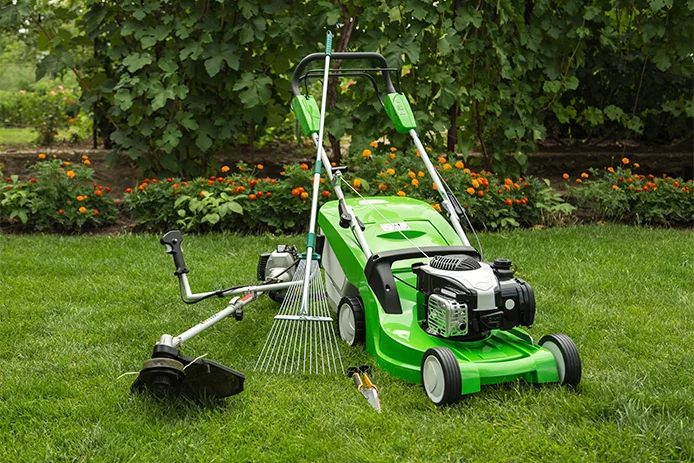 Mower along with other lawn equipment in the grass