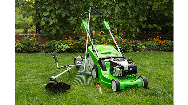 Mower along with other lawn equipment in the grass