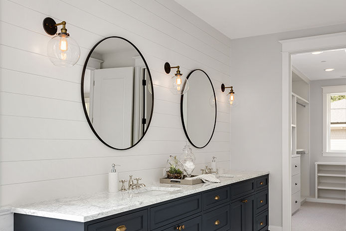 Wall sconces in bathroom on a white shiplap wall