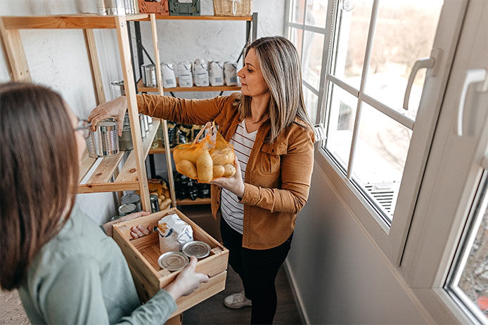 Two women stocking a pantry