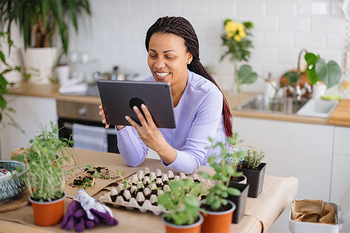 Woman on her tablet surrounded by plants