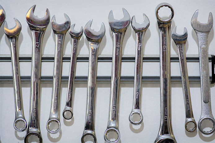 Wrenches hanging from a magnetic tool bar