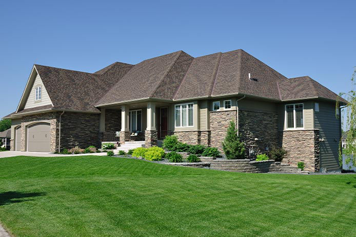 A modern family home with a lush green lawn out front