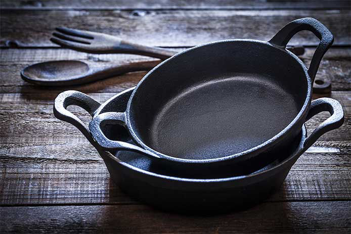 Skillets stacked on a wooden tabletop