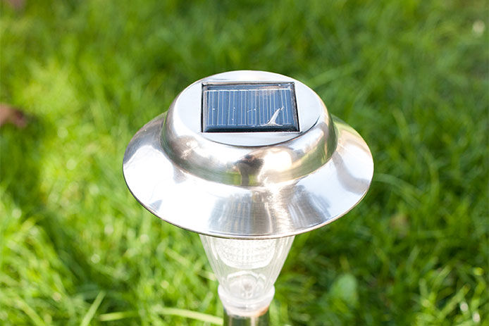 A top down view of a small solar panel on a garden landscaping solar light. 