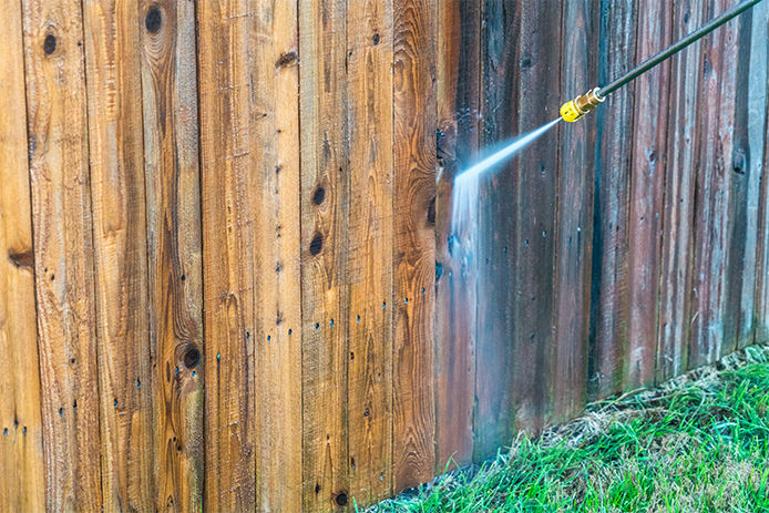 powerwahing a wooden fence in preparation to stain and seal it 