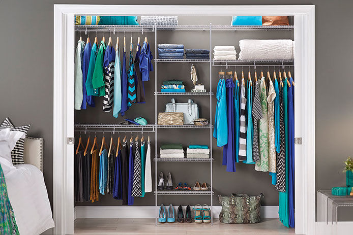 A colorful closet with clothes in shades of blue very well organized