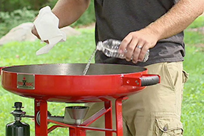 Man cleaning his FireDisc cooker