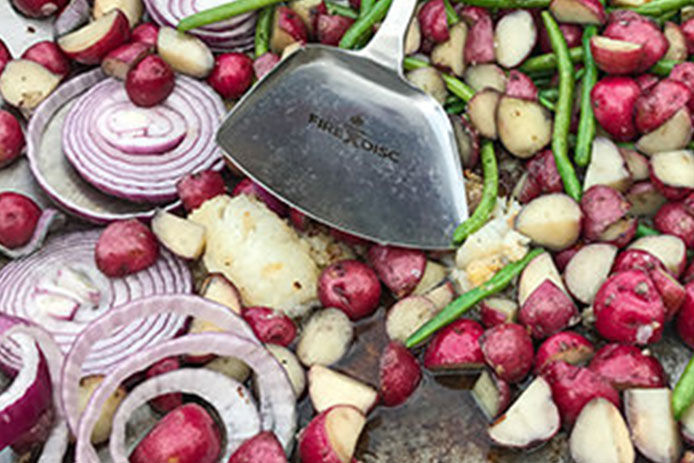 Red potatoes, red onions and green beans cooking in a FireDisc