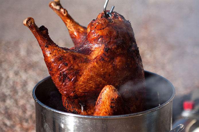 Pulling fried turkey from the deep fryer