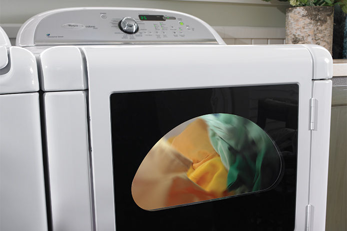 A close up of a dryer drying colorful towels 