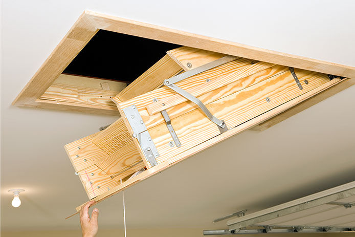 Person getting ready to pull down their newly installed attic ladder