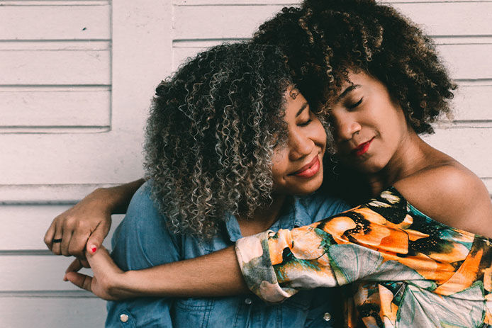 two young women embracing in a side hug