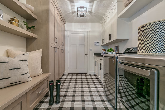 a view of a long hallway that was turned into a family mudroom. It also hold the laundry washer and dryer and a utility sink