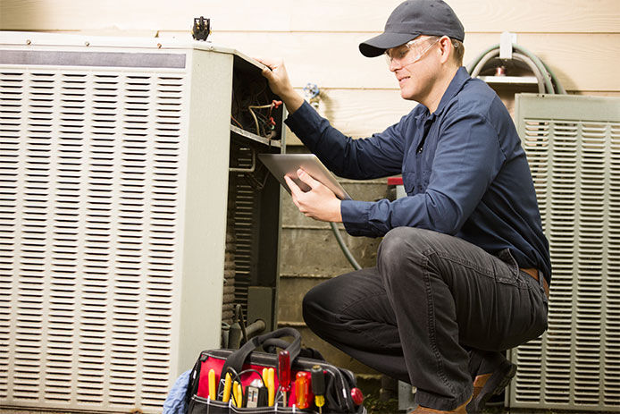 Maintenece man working on an AC unit